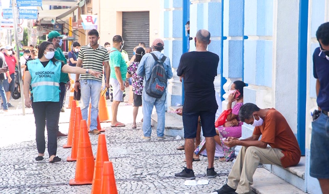 Educadores orientando a fila nas agências da Caixa 